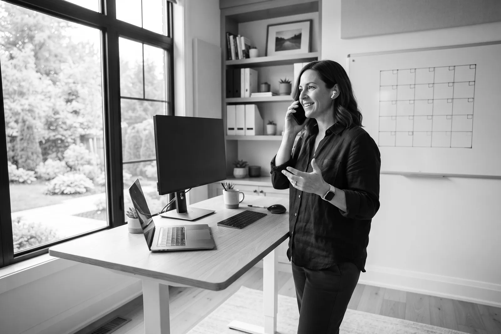 Business owner on a call at a standing desk in a bright home office